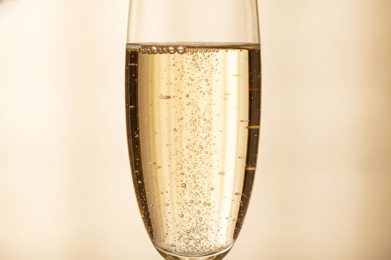 Aufsteigende feine Bläschen in einem Glas Champagner als Sinnbild für den strahlenden Aldehyd-Akkord