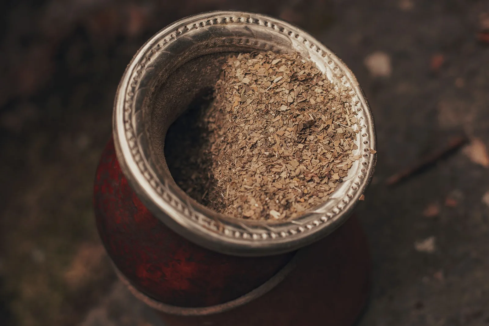 Getrocknete Mate-Blätter und grüner Mate-Tee in einer traditionellen Kalebasse