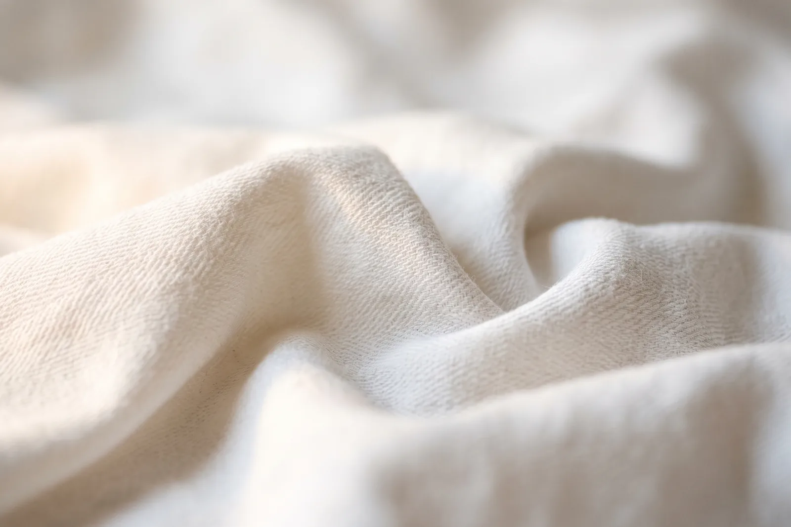Detailaufnahme von hellem Baumwollstoff in weichem Tageslicht als Bild für die textile Anmutung sauberer Düfte